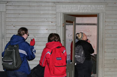 people photograhing historic graffiti in Harrington Opera House stage dressing rooms